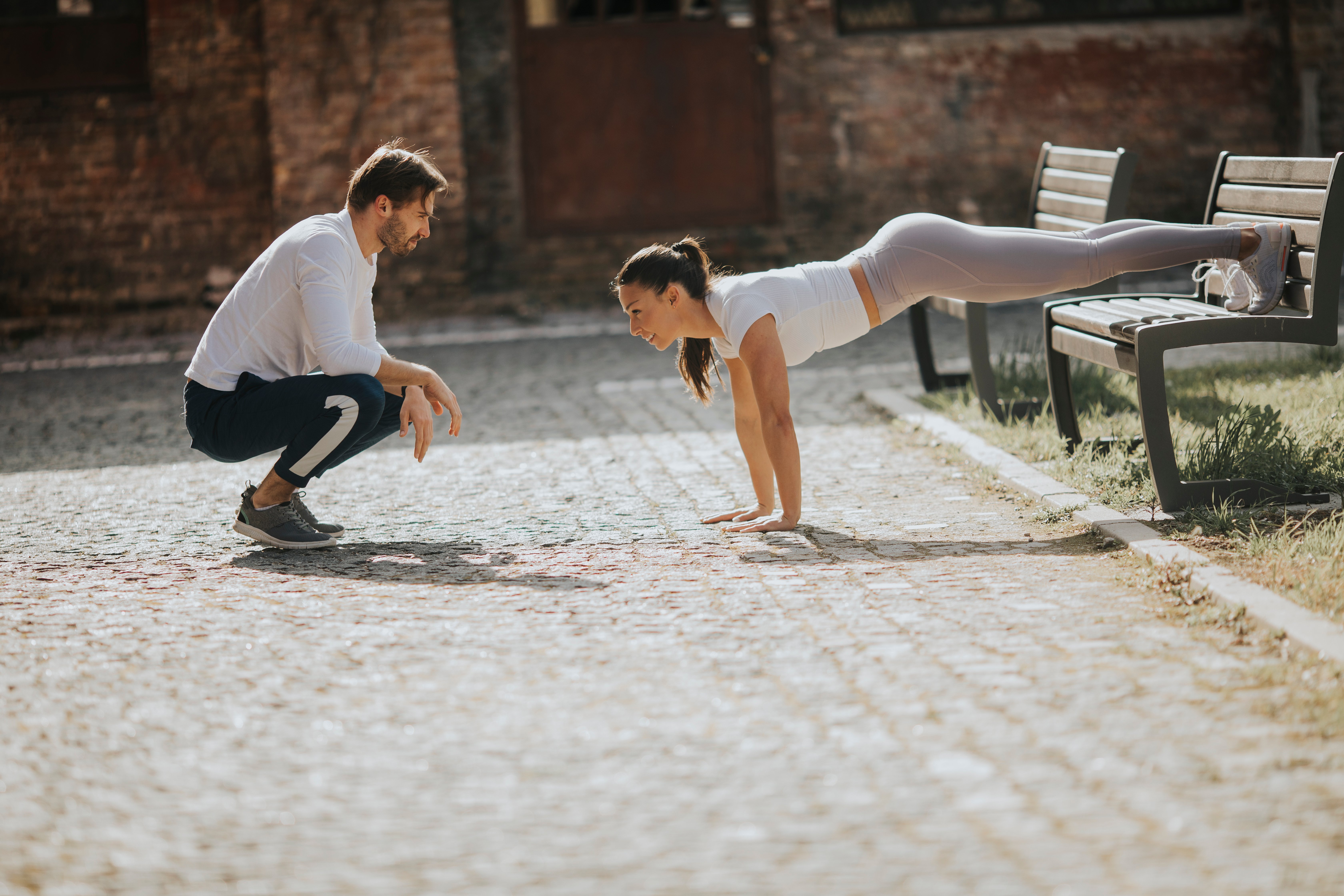 woman doing plank with personal trainer